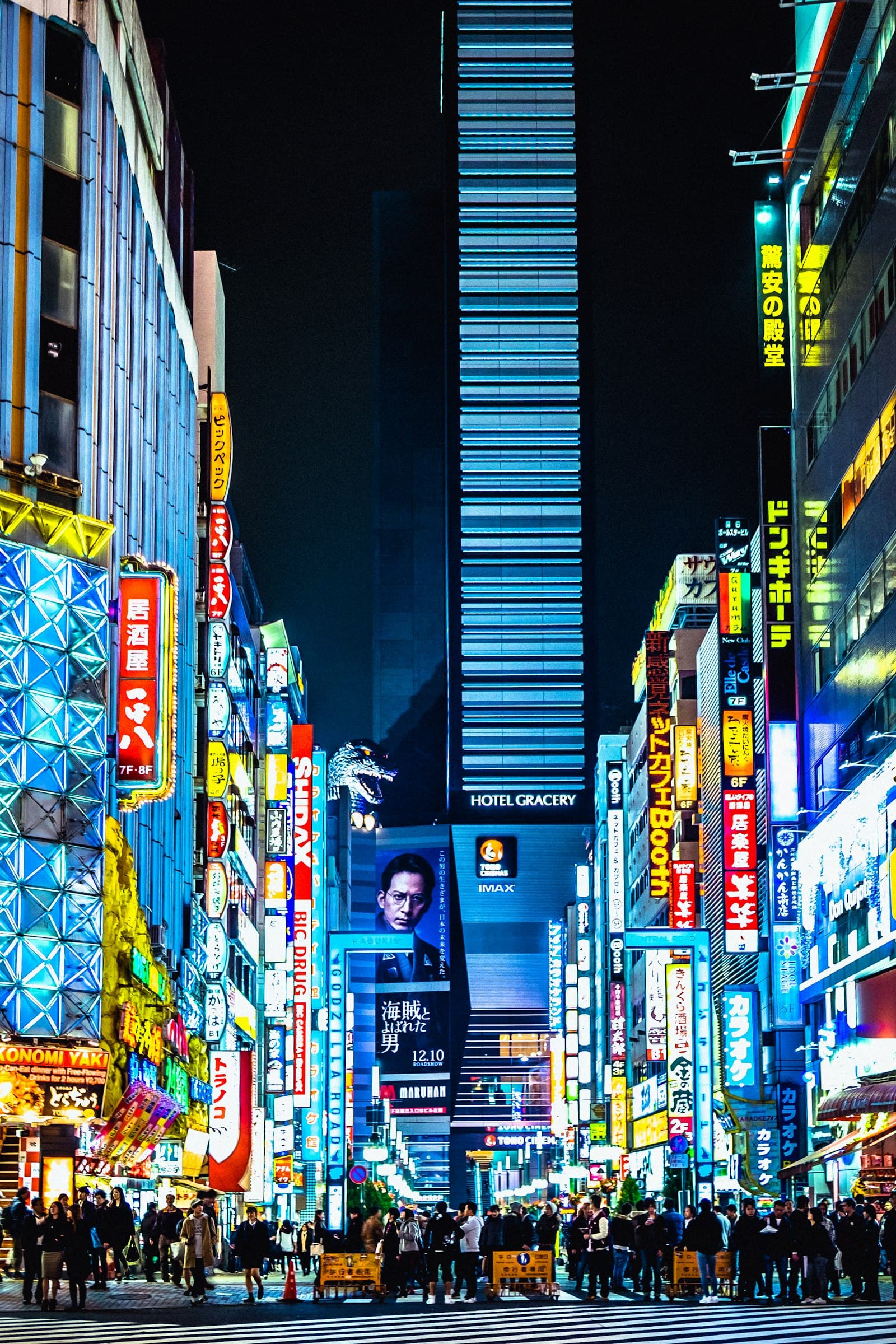 Small tour group walking through Akihabara Electric Town at dusk