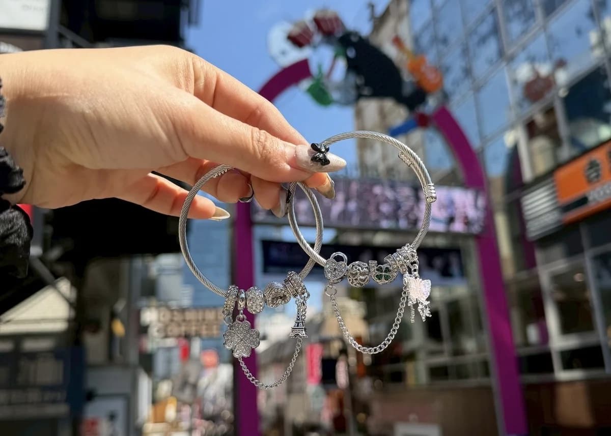 Snake bracelets held up with Harajuku Takeshita Street in the background