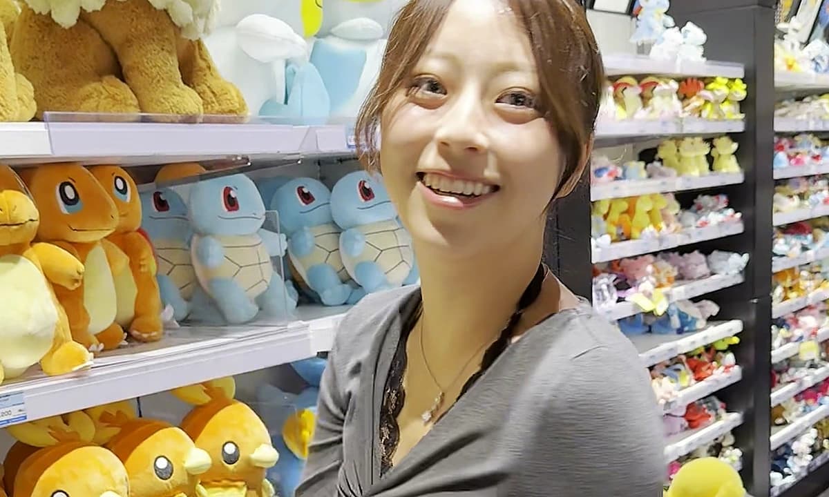 Pokemon Center Shibuya interior with a plush wall of Charmander, Squirtle, and Torchic behind a visitor inside Shibuya Parco, Tokyo 2026