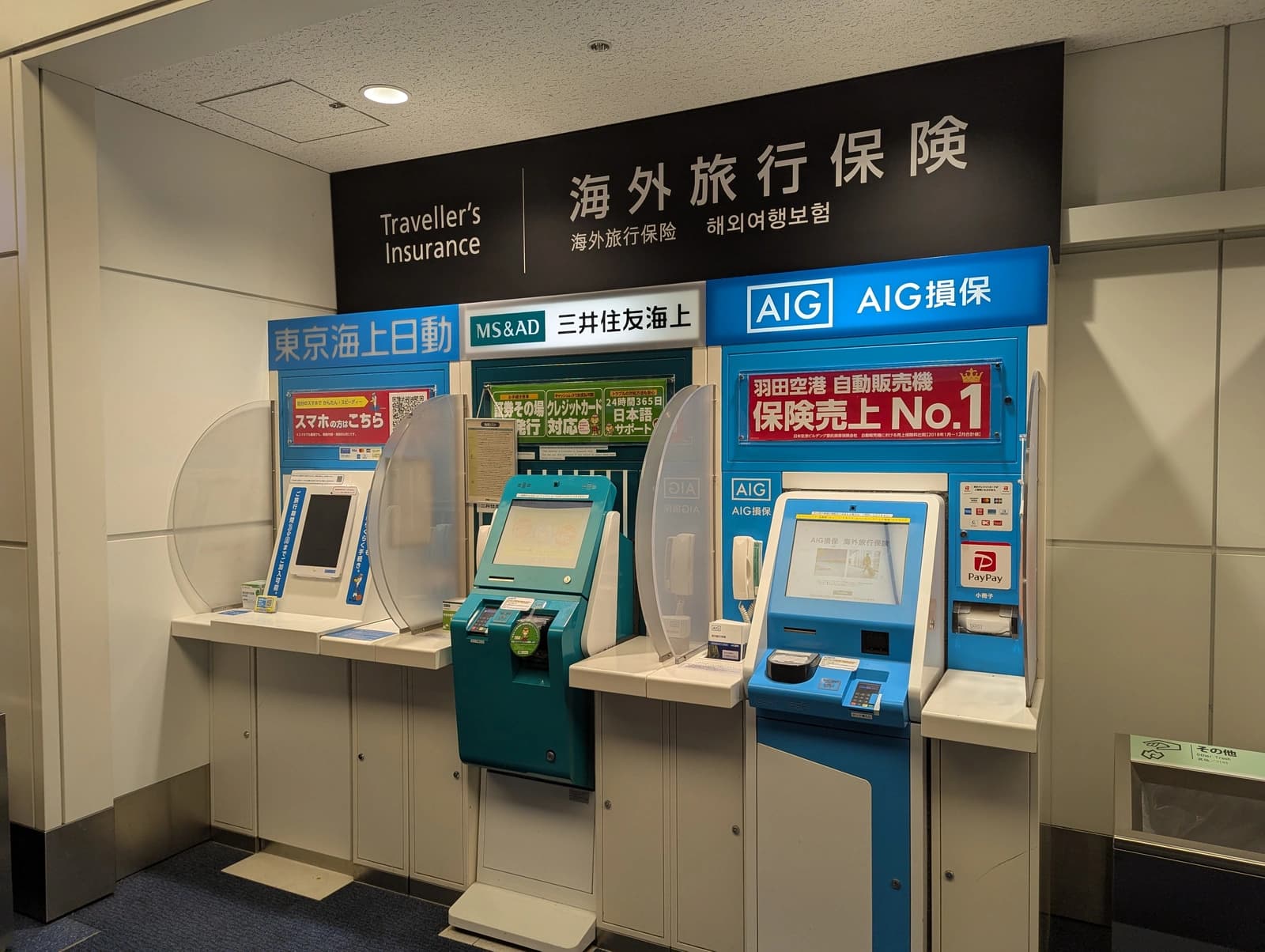 Traveller's Insurance vending machines at Haneda Airport Terminal 3 — Tokio Marine, MS&AD, and AIG Sonpo kiosks selling overseas travel insurance