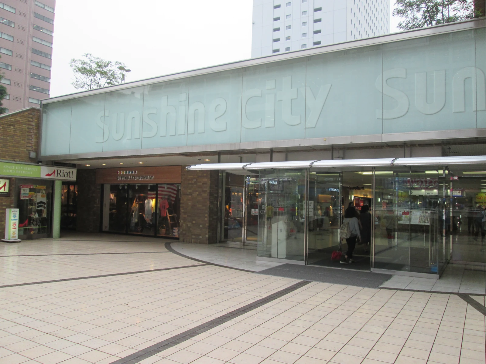 Sunshine City complex entrance in Ikebukuro with the green "sunshine city" signage above sliding glass doors