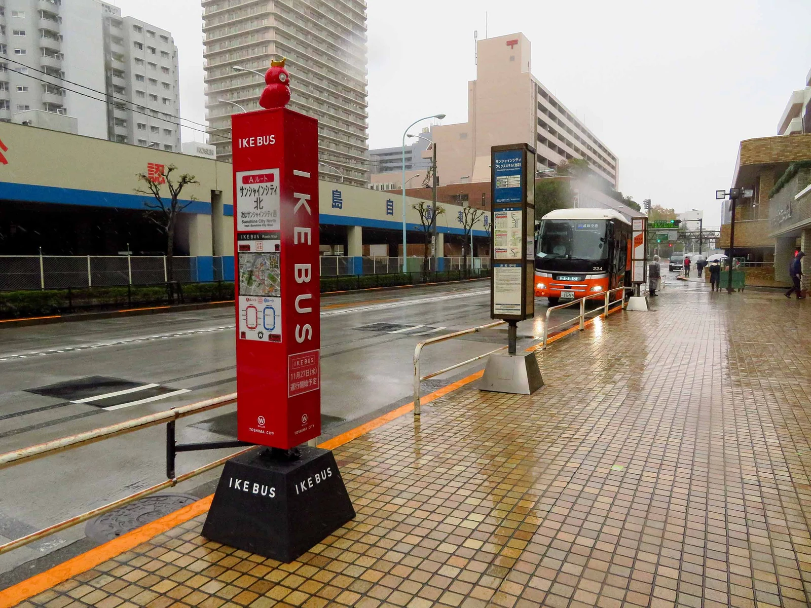 IKEBUS bus stop signage outside Sunshine City Prince Hotel in Ikebukuro on a rainy day