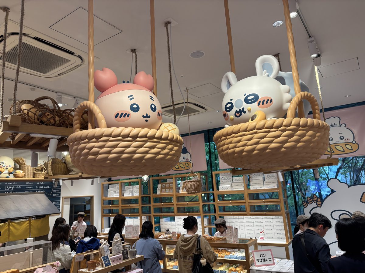 Giant Usagi and Hachiware character plush figures sitting in oversized woven baskets hanging from the ceiling of Chiikawa Bakery Harajuku