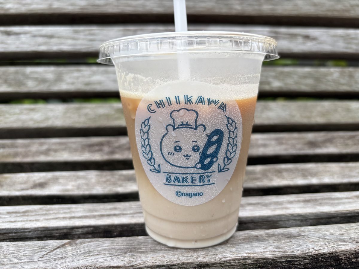 Chiikawa Bakery iced café latte in a branded logo cup photographed on an outdoor bench near Tokyu Plaza Omotesando