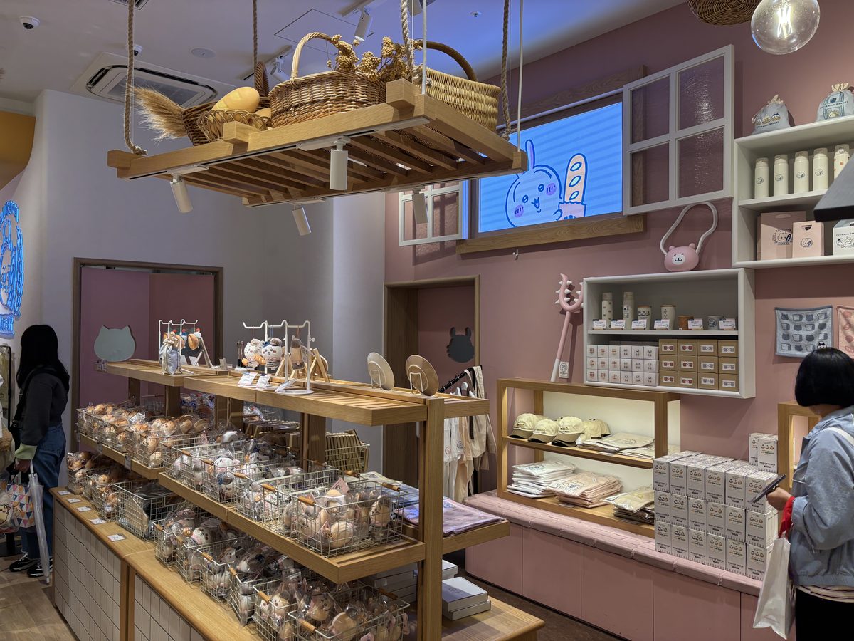Chiikawa Bakery merchandise area showing packaged rusks, coffee beans, and character accessories on wooden display shelves
