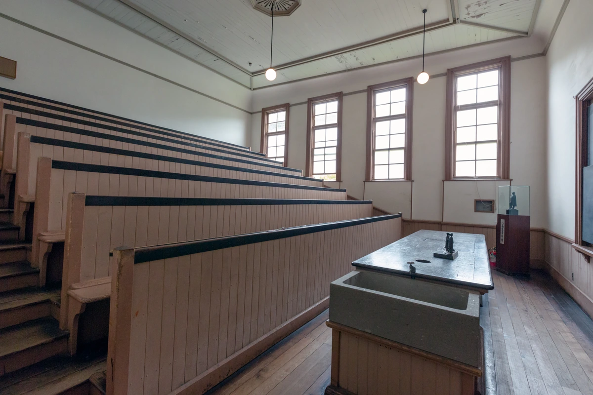 Interior of the Fourth National High School Physics and Chemistry Theater preserved at Museum Meiji-mura, the kind of Meiji-era classroom interior the escape-game cipher pages send recruits searching through