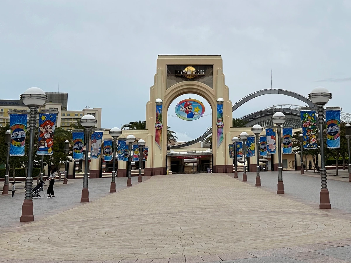Universal Studios Japan main gate facade in Osaka — the entry point guests scan their 1-Day Studio Pass before pulling the Frieren Story Walk e-seitai-ken in the USJ app