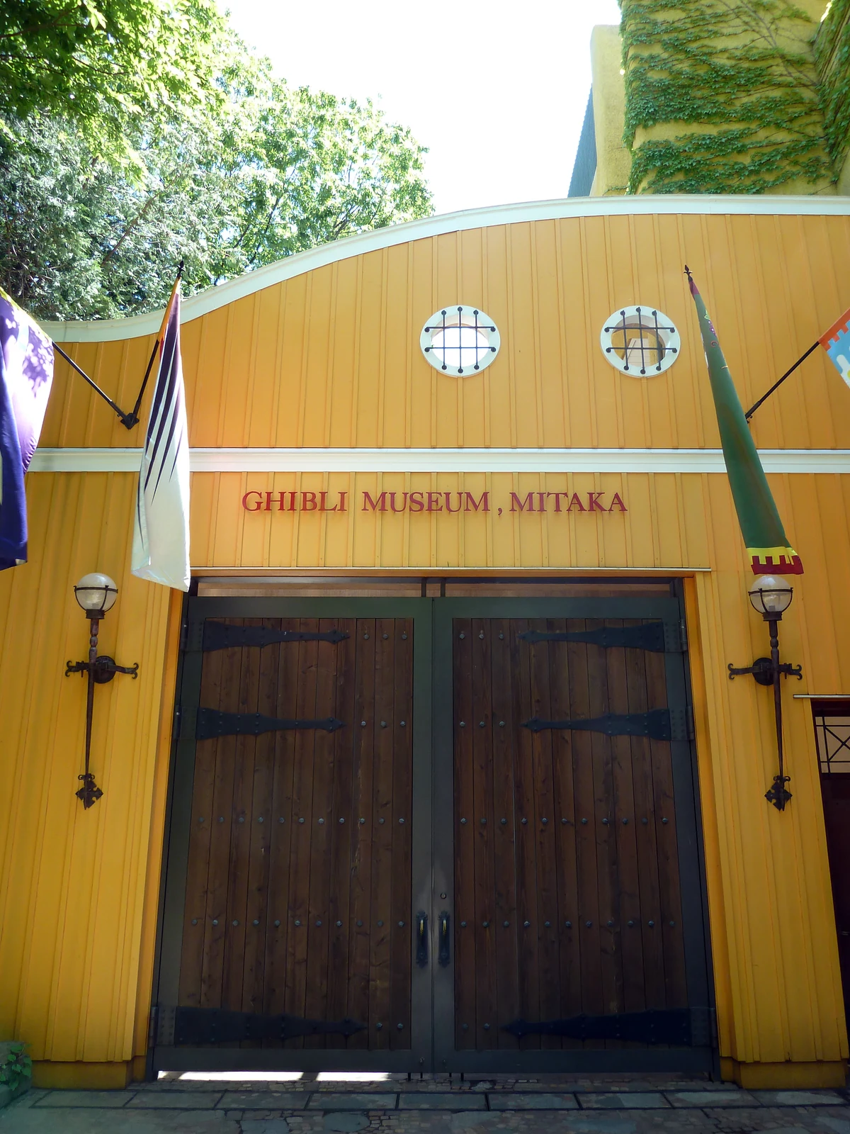 Ghibli Museum exterior detail showing the hand-laid stucco façade and the ivy-covered walls — the small-house scale of the Mitaka venue compared to Ghibli Park in Aichi