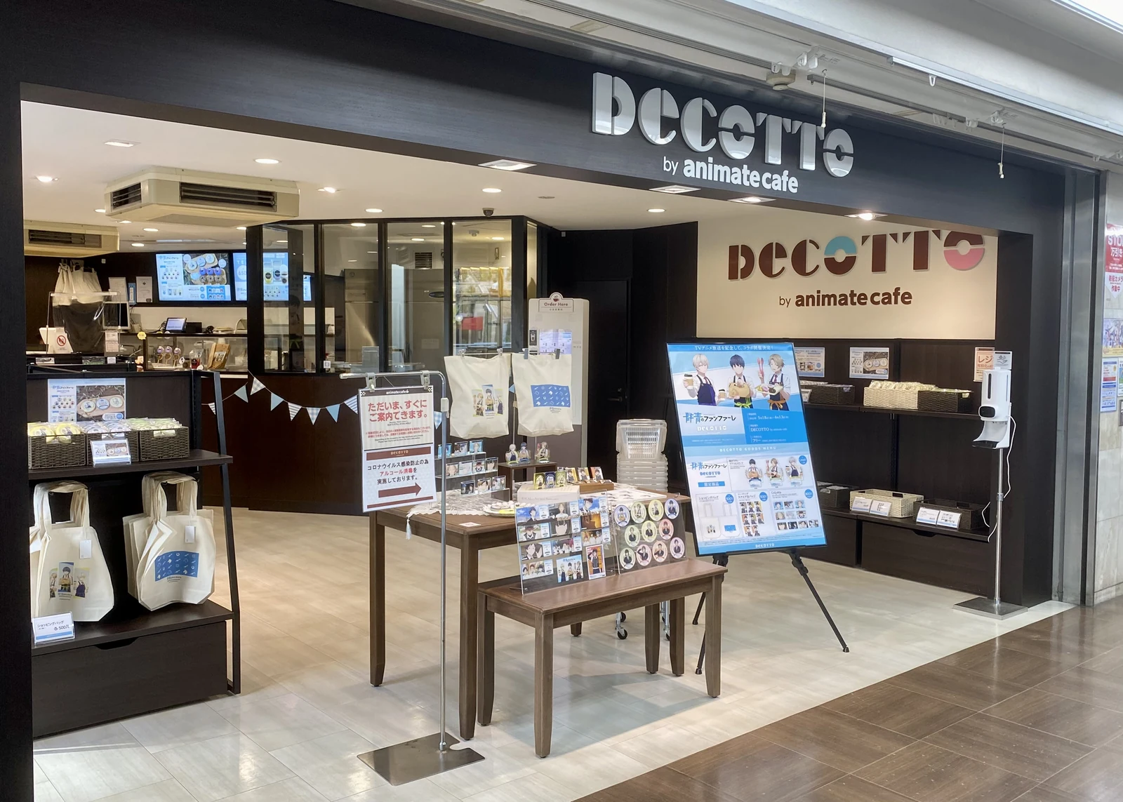 DECOTTO by animate cafe storefront with collab merch displays, banners, and standees in front of the entrance