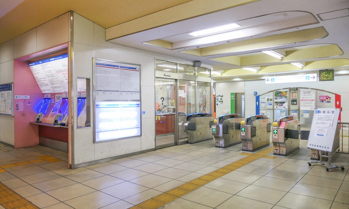 Row of JR East automatic ticket gates with IC card readers at Musashiseki Station, the standard gate-row layout for tapping in with a Suica or PASMO, with ticket vending machines and the station route map on the left wall