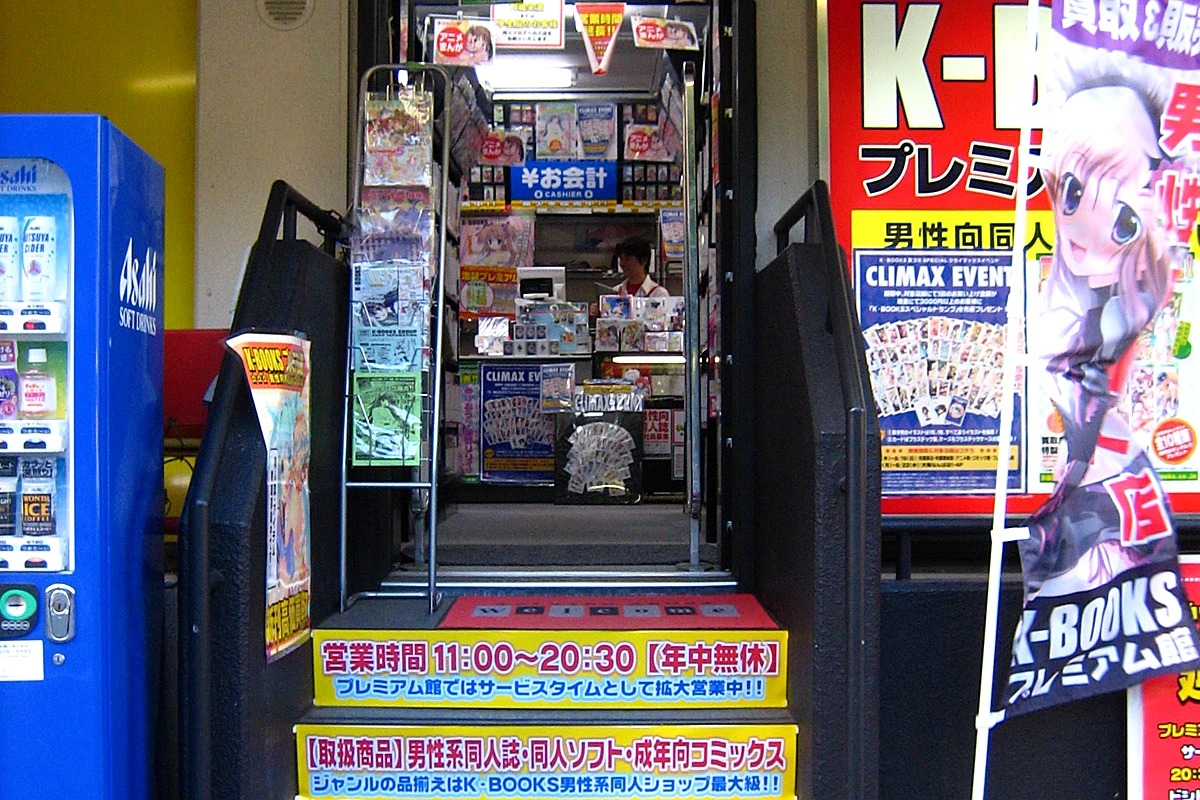 K-BOOKS storefront in Ikebukuro with male-oriented manga and doujinshi signage, one of the anchor shops on Otome Road's specialty strip