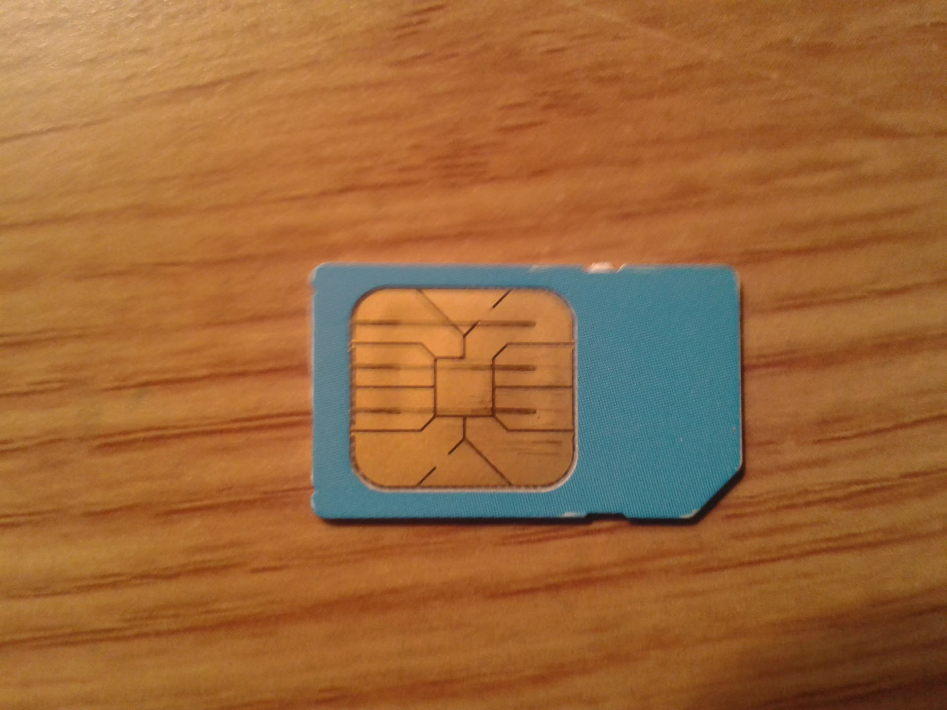 Close-up of a Nokia-branded SIM card on a wooden surface showing the gold contact pads, the same physical card you swap into your phone at a Japan airport SIM counter