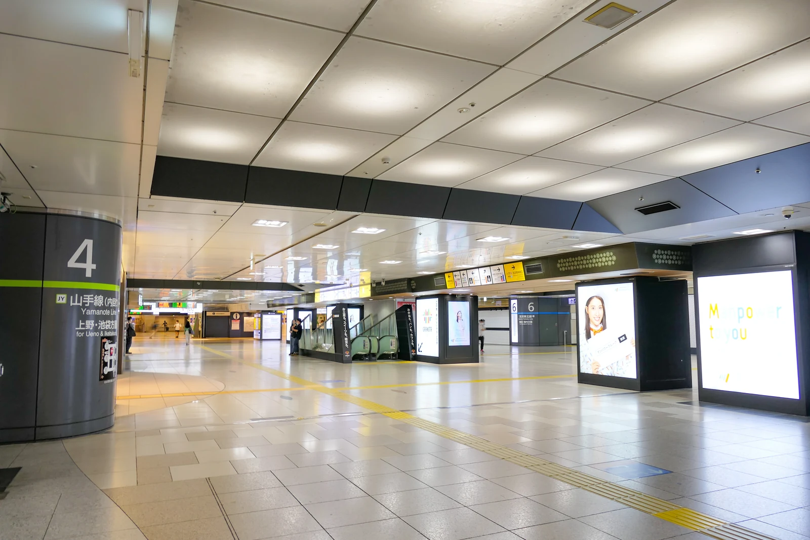 Real JR East concourse at Tokyo Station showing the Yamanote Line platform 4 pillar signage and the wide IC-card-tappable connector you walk through every transfer