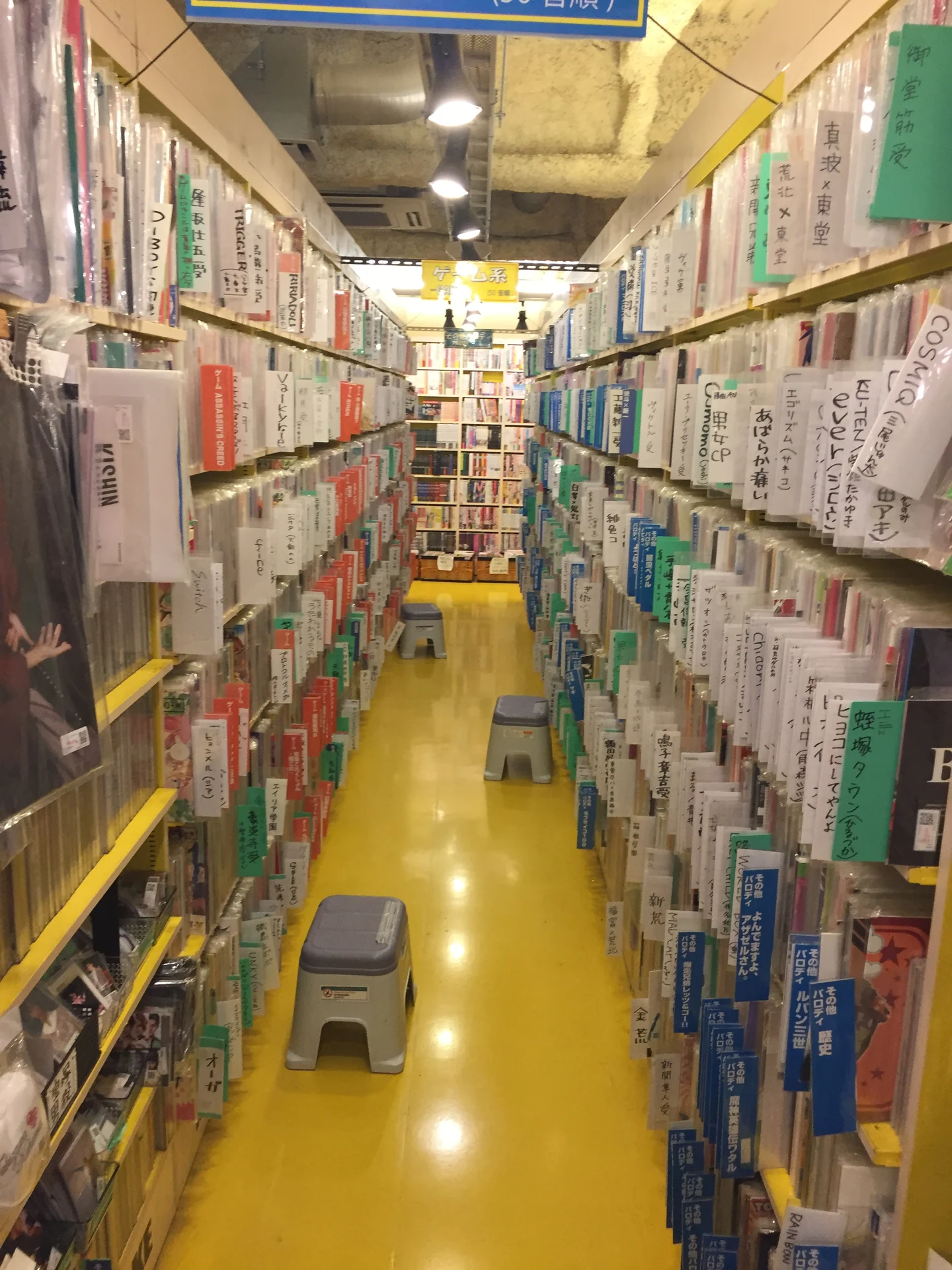 Rows of manga and used media organized on bright yellow shelves inside a Mandarake store in Akihabara, typical inventory proxy services photograph for warehouse confirmations