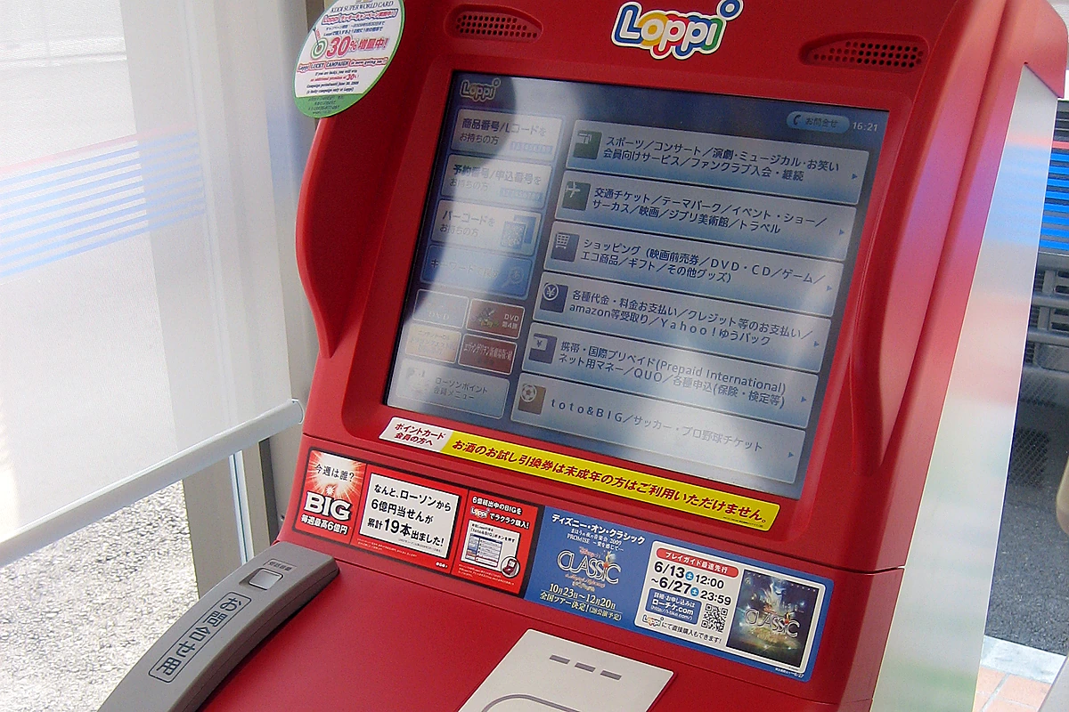 Loppi ticket kiosk inside a Lawson convenience store in Japan, with Japanese touchscreen menu for reservation pickup