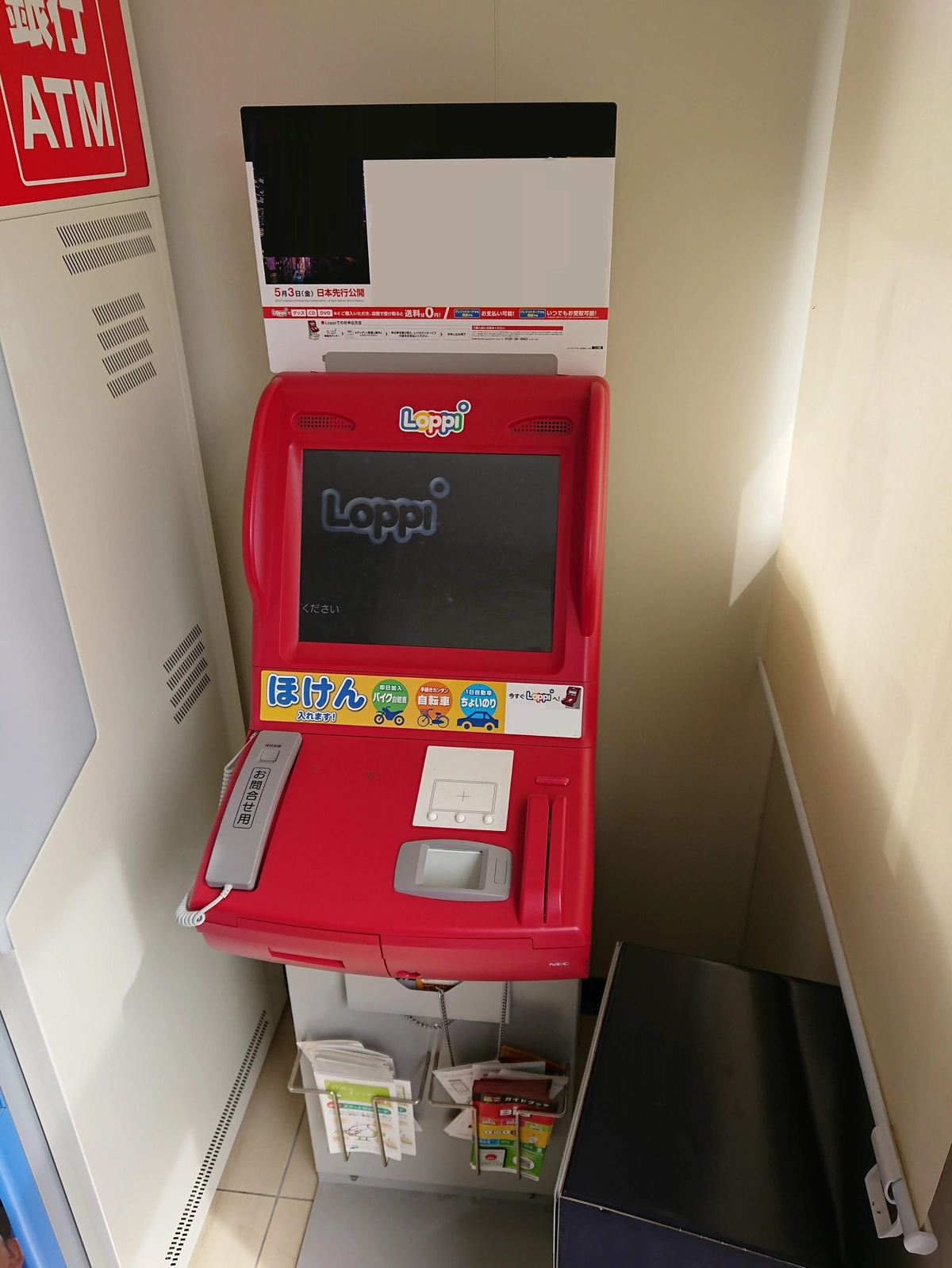 Current-generation Loppi self-service kiosk inside a Lawson convenience store, with red signage and Japanese touchscreen menu