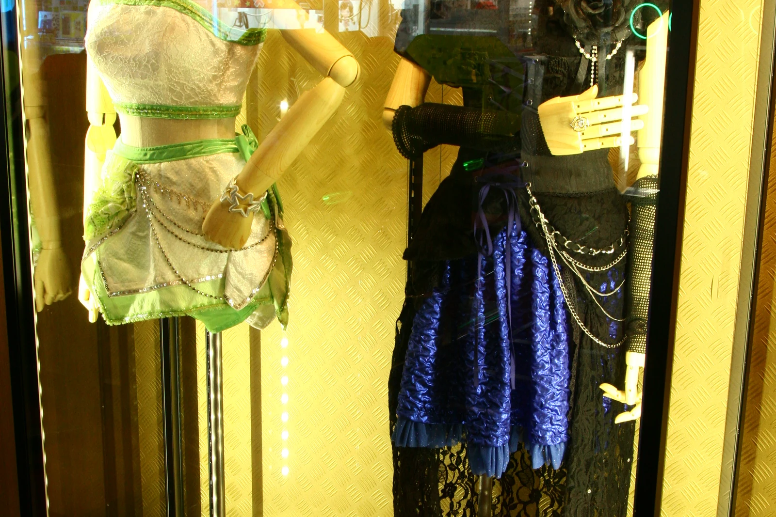 Idolmaster concert-costume display at a Den Den Town shop, the idol-fandom merchandise that fills Nipponbashi storefronts