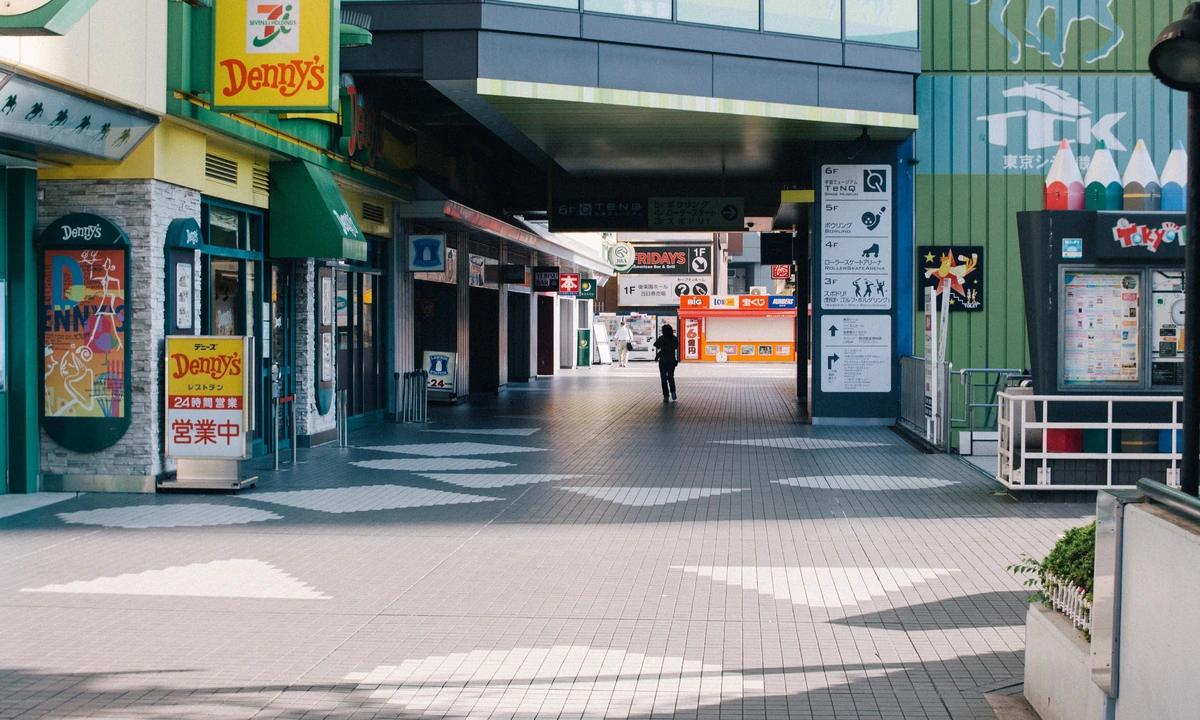 Tokyo Dome City pedestrian deck with Hi!EVERYVALLEY container-row storefronts in the background — the venue area for the World Trigger Festival 2026 cafe at THE Chara CAFE STAND
